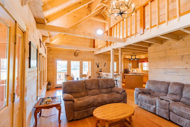 living room featuring beam ceiling, wooden walls, and plenty of natural light