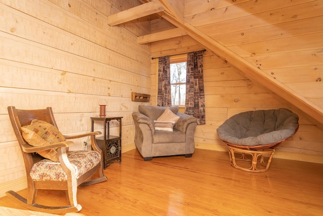 living area with wooden walls, wood finished floors, and vaulted ceiling