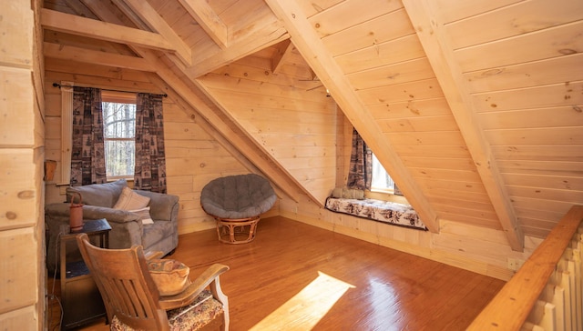 living area with wooden ceiling, wooden walls, vaulted ceiling with beams, and wood finished floors