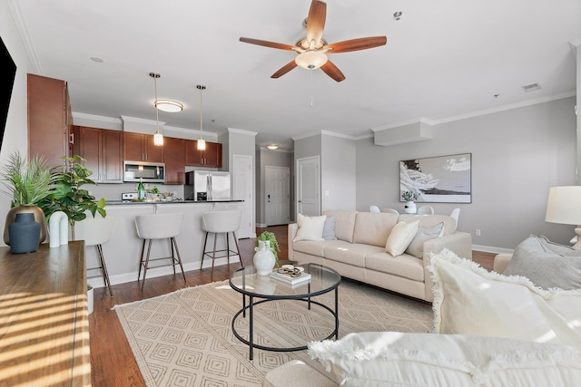 living room featuring light hardwood / wood-style flooring, ceiling fan, and crown molding