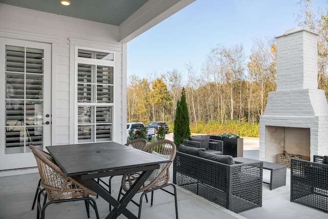 view of patio with an outdoor living space with a fireplace