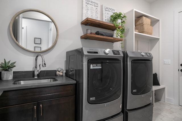 laundry area featuring washer and dryer, light tile patterned flooring, cabinets, and sink