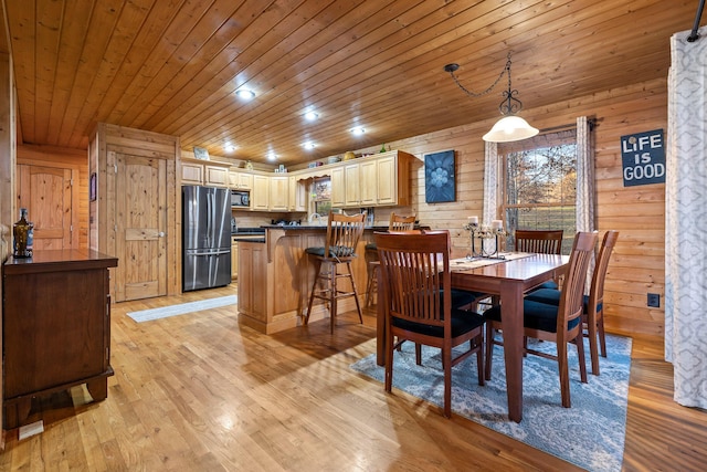 dining area featuring wood walls, light hardwood / wood-style flooring, and wood ceiling