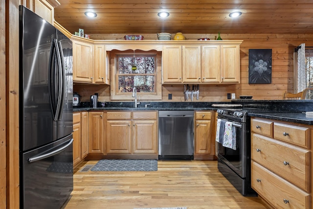 kitchen with sink, wooden ceiling, light hardwood / wood-style flooring, dark stone counters, and black appliances