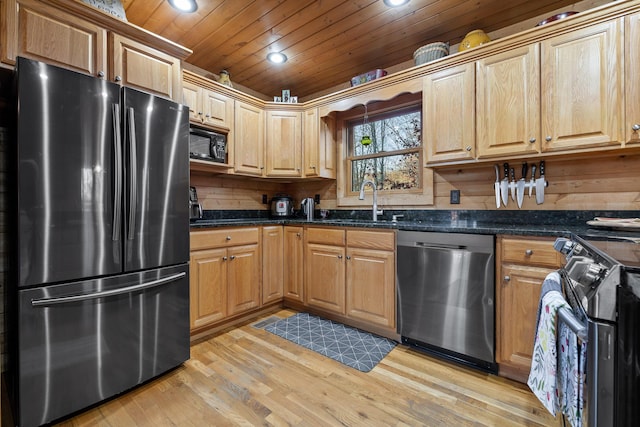 kitchen with sink, stainless steel appliances, dark stone counters, wood ceiling, and light wood-type flooring