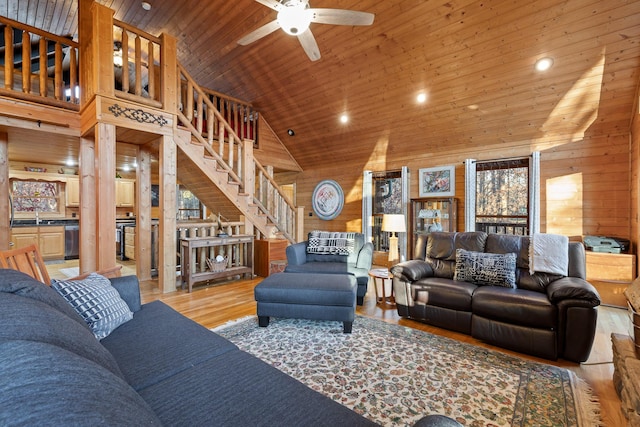 living room with wooden walls, ceiling fan, wood ceiling, and high vaulted ceiling