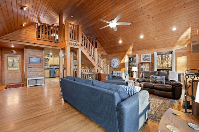 living room featuring wood walls, high vaulted ceiling, light hardwood / wood-style flooring, ceiling fan, and wood ceiling