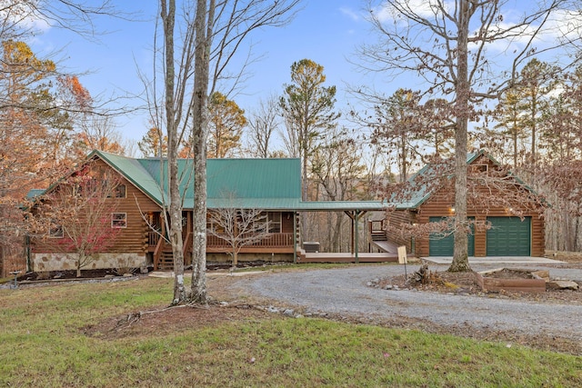 log home with a front lawn, a porch, and a garage