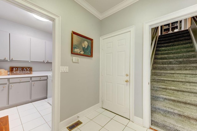 doorway with light tile patterned floors and ornamental molding