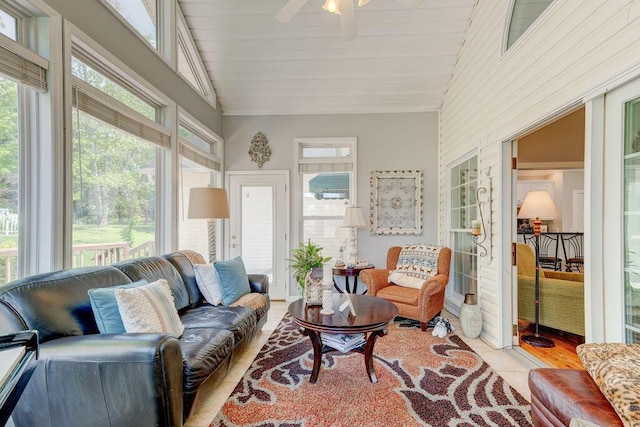 sunroom featuring ceiling fan, a healthy amount of sunlight, and vaulted ceiling