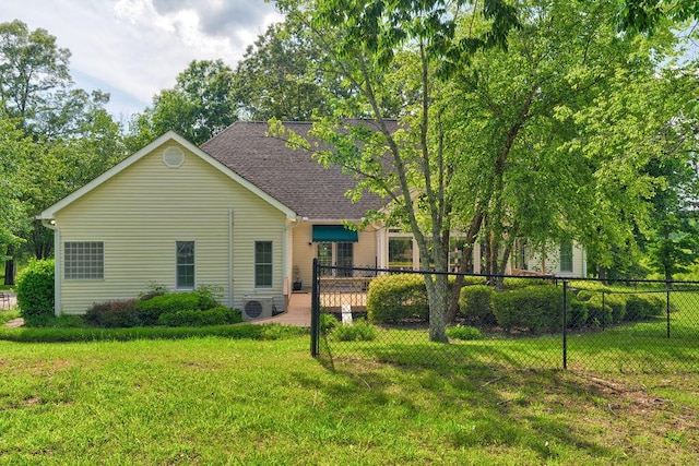 back of property featuring a lawn and ac unit