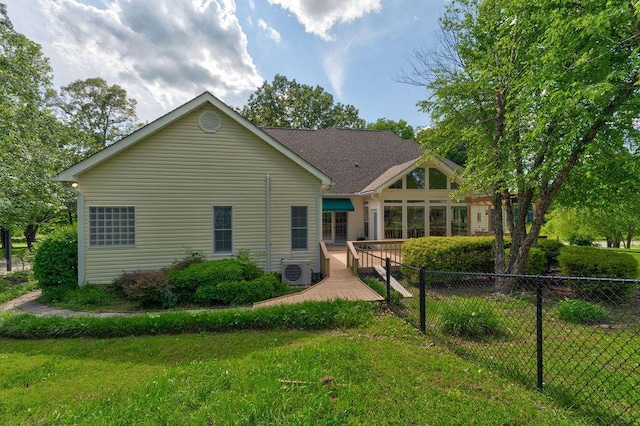 back of house featuring a lawn and ac unit