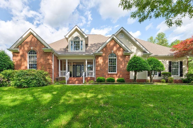 front facade with covered porch and a front yard