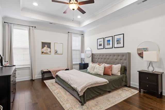 bedroom featuring a raised ceiling, multiple windows, ceiling fan, and dark hardwood / wood-style floors