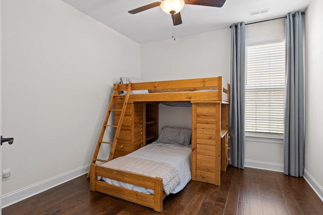 bedroom with ceiling fan, dark hardwood / wood-style flooring, and multiple windows