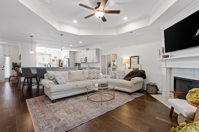 living room featuring ceiling fan, dark hardwood / wood-style flooring, and crown molding