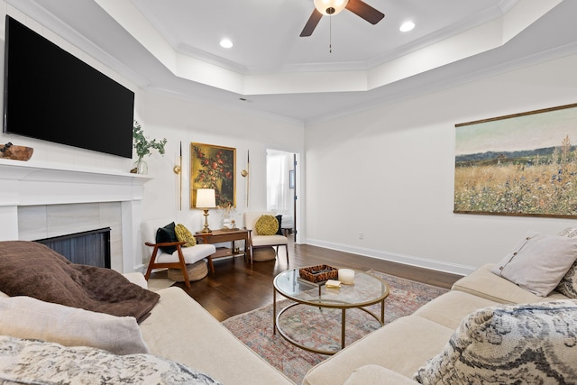 living room featuring a tray ceiling, dark hardwood / wood-style floors, and ornamental molding