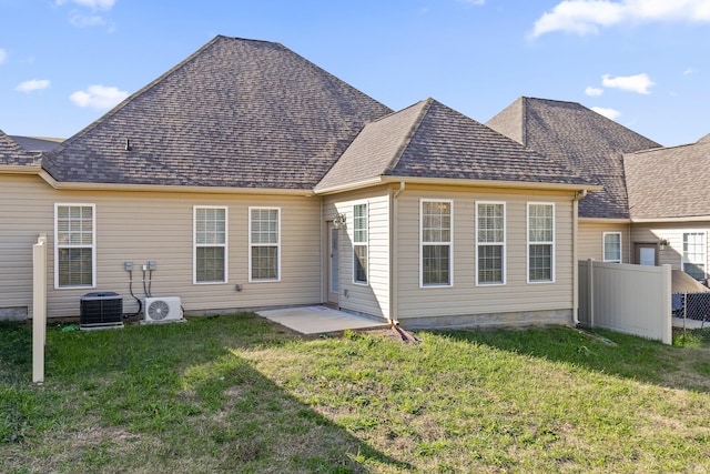 back of house with ac unit, central air condition unit, and a lawn