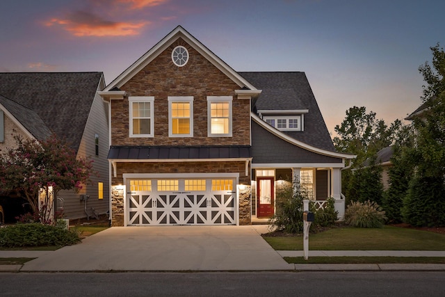 craftsman inspired home with a garage and a yard