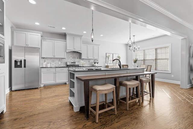 kitchen featuring a center island with sink, a kitchen breakfast bar, white cabinets, stainless steel fridge, and wood-type flooring