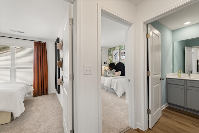 interior space with light carpet, ensuite bath, and sink