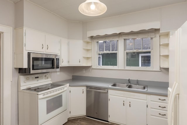 kitchen featuring stainless steel appliances, white cabinetry, dark hardwood / wood-style floors, and sink