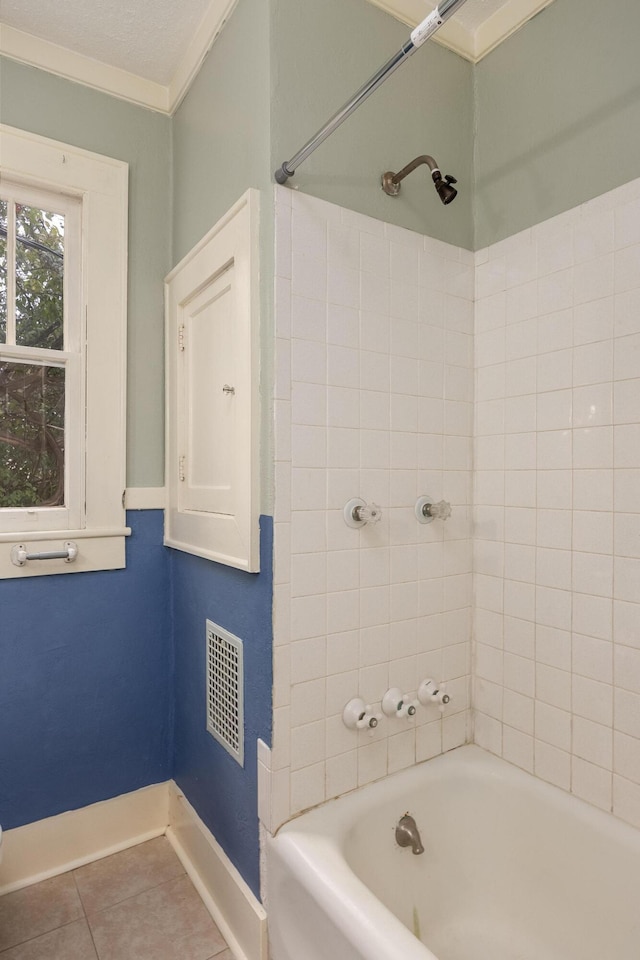 bathroom featuring tile patterned floors, tiled shower / bath combo, crown molding, and a textured ceiling