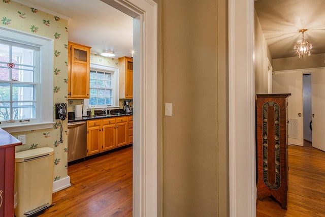 hall with hardwood / wood-style floors, a chandelier, and sink