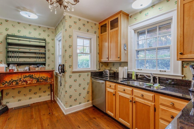 kitchen with dishwasher, dark hardwood / wood-style flooring, dark stone countertops, and a wealth of natural light