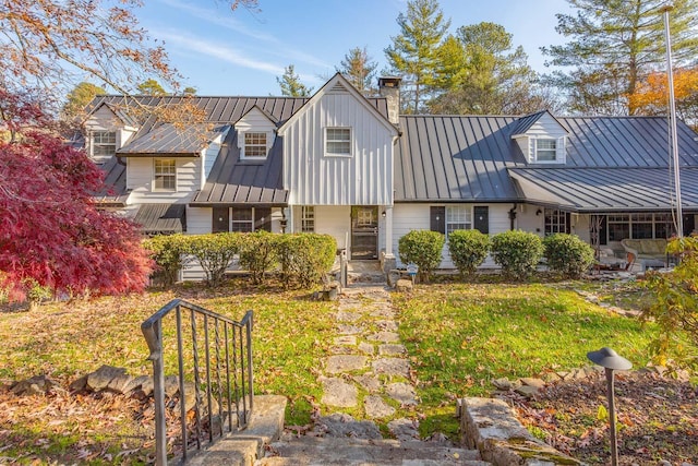 cape cod house with a front yard