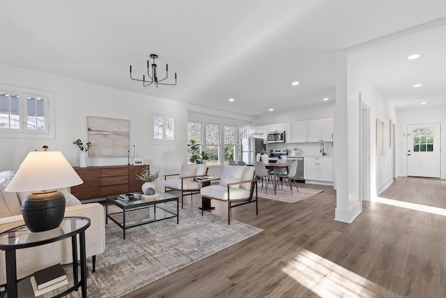 living room featuring hardwood / wood-style floors, sink, and a chandelier