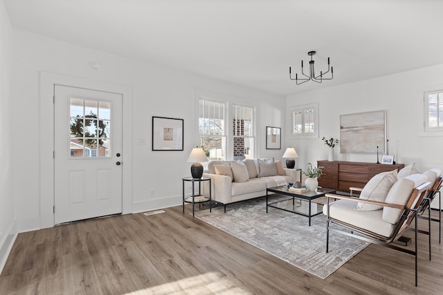 living room with an inviting chandelier and light hardwood / wood-style flooring