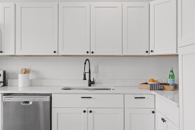 kitchen featuring stainless steel dishwasher, white cabinets, and sink