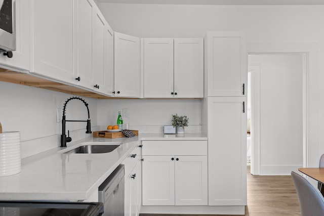 kitchen featuring dishwasher, light hardwood / wood-style floors, white cabinetry, and sink