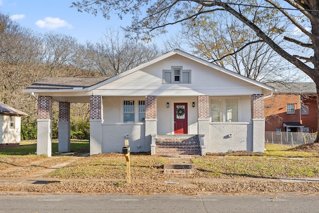 bungalow-style home with a front lawn and a porch