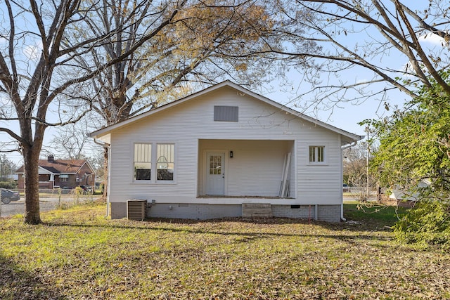 rear view of property with a yard and central AC