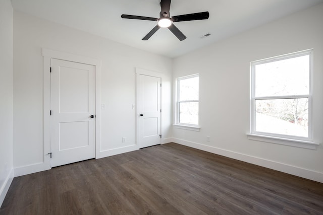 unfurnished bedroom with ceiling fan and dark hardwood / wood-style floors