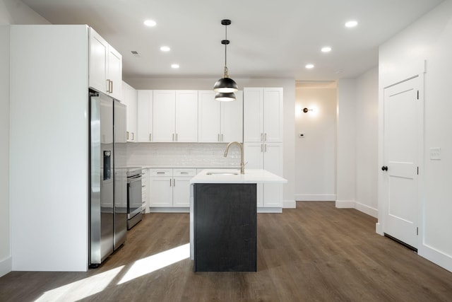 kitchen featuring dark wood-type flooring, sink, an island with sink, decorative light fixtures, and white cabinetry