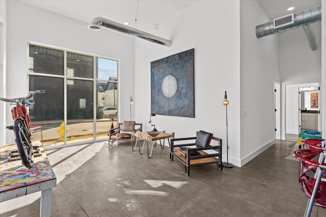 sitting room featuring a towering ceiling