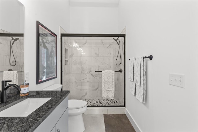 bathroom featuring vanity, toilet, and a shower with door