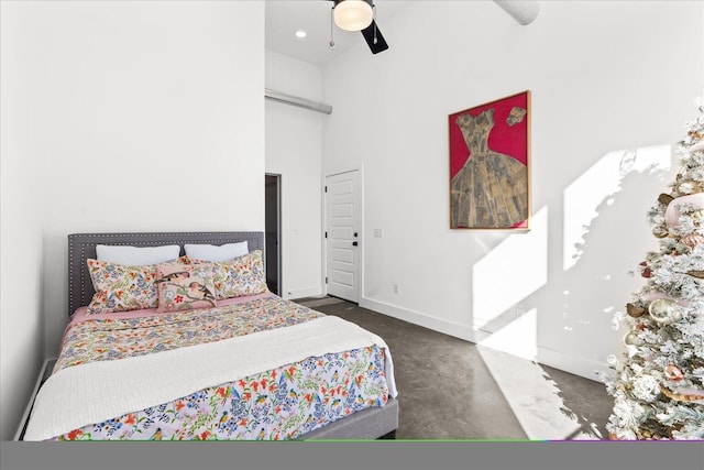 bedroom with ceiling fan and a towering ceiling