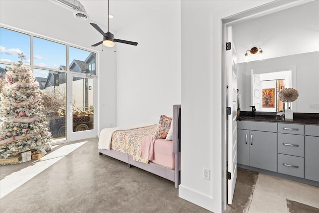 bedroom featuring ceiling fan, concrete flooring, and a high ceiling