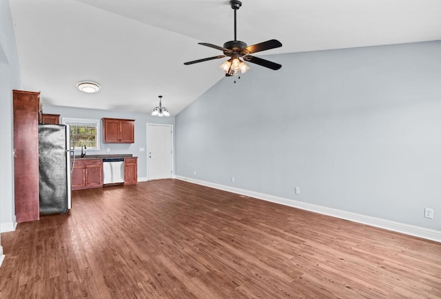 unfurnished living room featuring dark hardwood / wood-style floors, sink, ceiling fan with notable chandelier, and vaulted ceiling