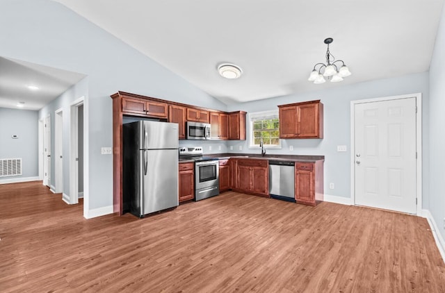 kitchen with hardwood / wood-style floors, decorative light fixtures, stainless steel appliances, and a chandelier