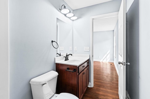 bathroom with wood-type flooring, vanity, and toilet