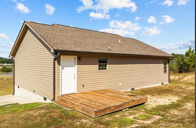 back of property featuring a wooden deck and a lawn