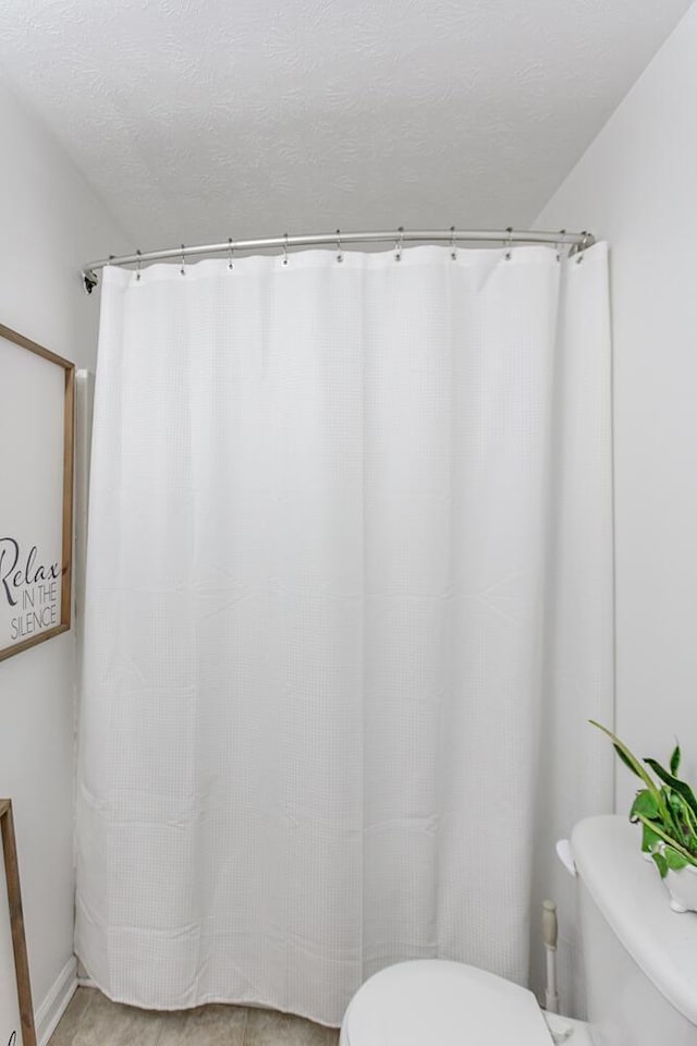 bathroom featuring a textured ceiling and toilet