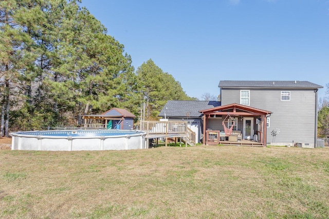 rear view of property with a yard and a swimming pool side deck