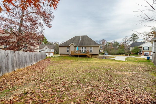 back of property featuring a wooden deck and a yard