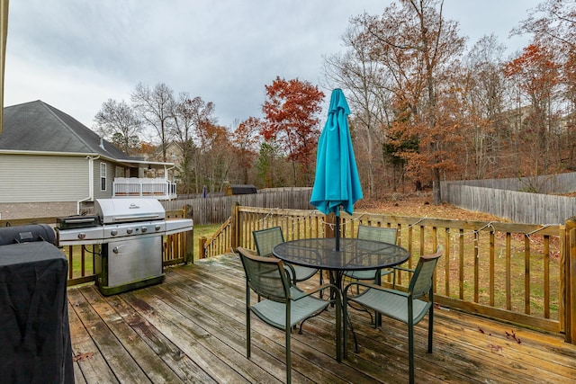 wooden deck with a grill and a yard